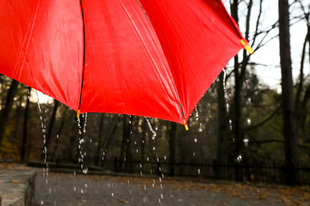 Open red umbrella under pouring rain outdoors, closeupの写真素材
