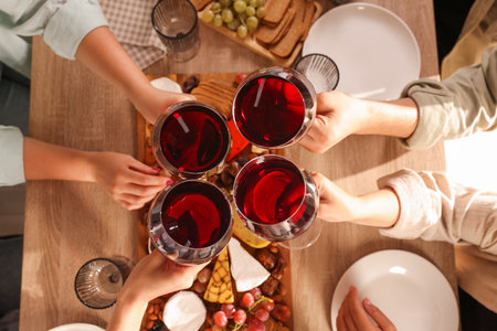 People clinking glasses of red wine at served table, top viewの写真素材