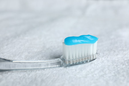 Toothbrush with toothpaste on white towel, closeupの写真素材
