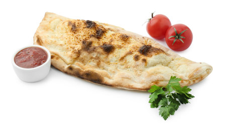 Delicious calzone with fresh parsley, tomatoes and ketchup isolated on whiteの写真素材