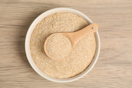 Oat bran in bowl and spoon on wooden table, top viewの写真素材
