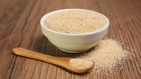 Oat bran in bowl and spoon on wooden table, closeupの写真素材