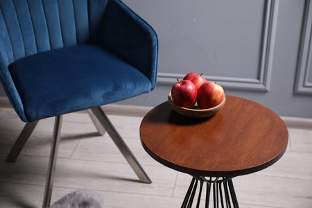 Fresh apples on wooden coffee table near armchair indoorsの写真素材