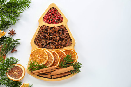 Different spices, dried orange slices and fir tree branches on white table, flat lay with space for...