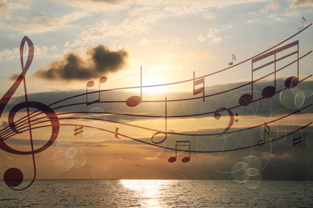 Musical symbols in beautiful sky with clouds over sea at sunsetの写真素材