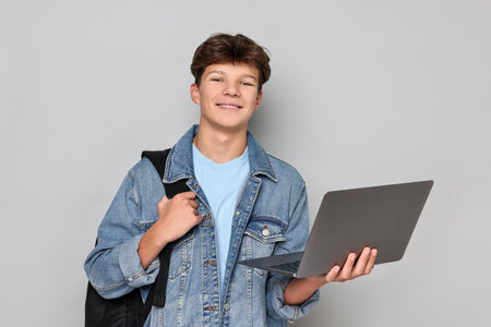 Person with laptop and backpack on light grey backgroundの写真素材