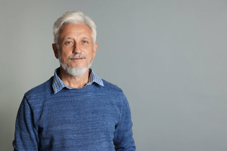Portrait of senior man on gray background, space for textの写真素材