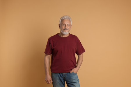Portrait of senior man on beige background
