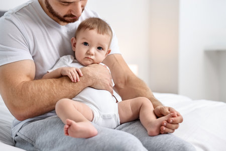 Father with his little baby on bed at home, closeup