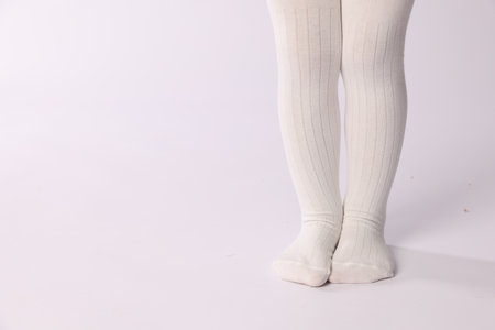 Child wearing tights on white background, closeup. Space for textの写真素材