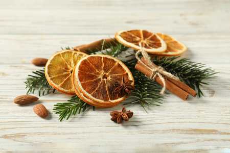 Different spices, dried orange slices and fir tree branches on white wooden table. Christmas seasonの写真素材