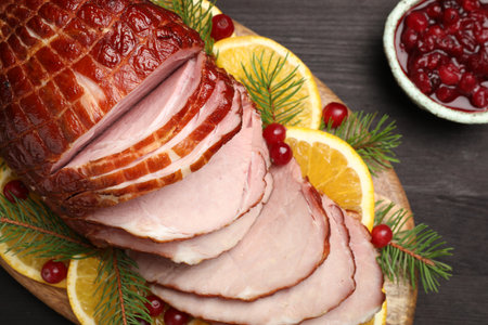 Tasty baked ham served on black wooden table, flat layの写真素材