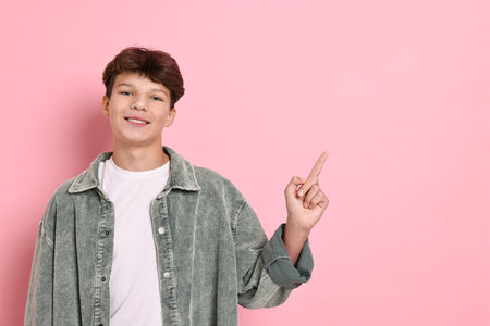 Happy teenage boy on pink background, space for textの写真素材