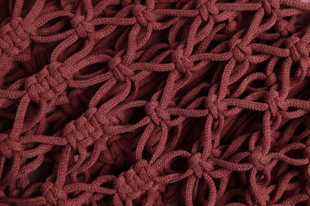 Macrame shopping bag as background, top view