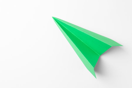 One handmade green paper plane on white background, top view. Space for textの写真素材