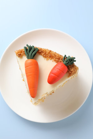 Piece of delicious carrot cake on light blue background, top viewの写真素材
