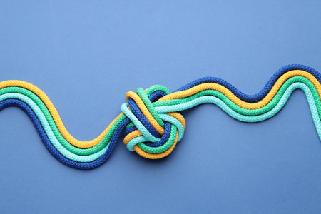 Colorful ropes tied in knot on blue background, top view. Unity conceptの写真素材
