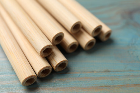 Bamboo drinking straws on light blue wooden table, closeupの写真素材