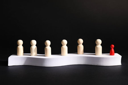 Winner. Red pieces among wooden ones on podium against black backgroundの写真素材