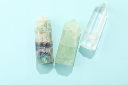 Beautiful natural gemstones on light blue background, flat lay