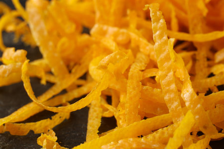 Pile of fresh orange zest on black table, closeupの写真素材