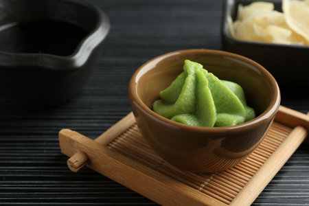 Hot wasabi paste, soy sauce and ginger on black textured table, closeupの写真素材