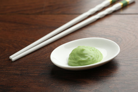 Hot wasabi paste and chopsticks on wooden table, closeupの写真素材