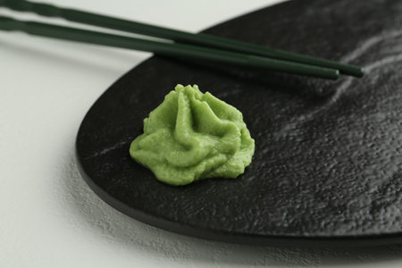 Slate board with hot wasabi paste and chopsticks on light textured table, closeupの写真素材