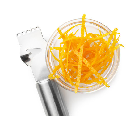 Orange zest and zester tool isolated on white, top view