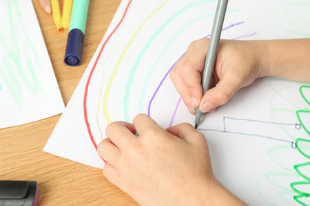 Boy drawing picture at wooden table, closeupの写真素材