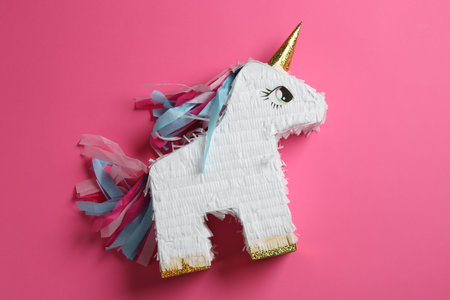 Bright pinata in shape of unicorn on pink background, top viewの写真素材