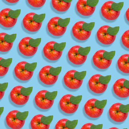 Pattern of fresh red apples on light blue backgroundの写真素材