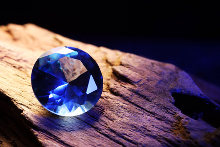 Beautiful shiny light blue gemstone on stone against dark background, closeupの写真素材
