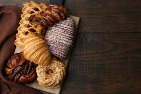 Different sweet pastries on wooden table, top view. Space for textの写真素材
