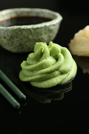 Hot wasabi paste, soy sauce and chopsticks on black mirror surface, closeupの写真素材