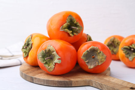 Delicious fresh juicy persimmons on white table, closeupの写真素材