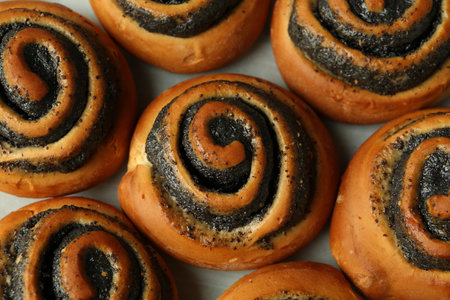 Tasty buns with poppy seeds on parchment, flat layの写真素材