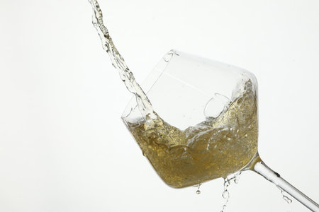 Pouring wine into glass on white backgroundの写真素材