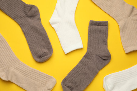 Different soft socks on yellow background, flat layの写真素材