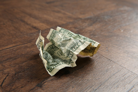 One crumpled dollar banknote on wooden table, closeupの写真素材