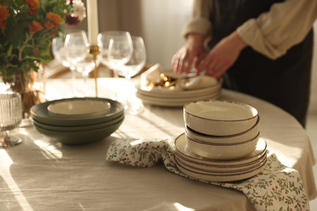 Woman setting table for dinner at home, closeupの写真素材