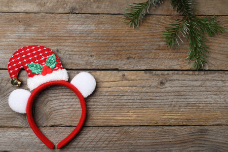 Stylish party headband and fir branch on wooden background, top view with space for text. Christmas accessoryの写真素材