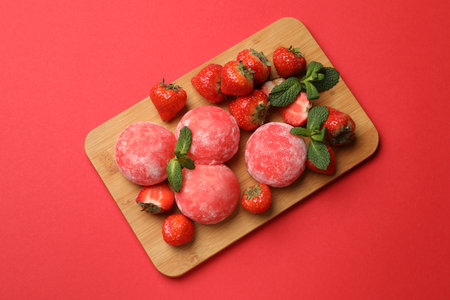 Delicious mochi, strawberries and mint on red background, top viewの写真素材
