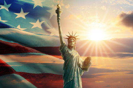 Statue of Liberty against American flag and sunset skyの写真素材
