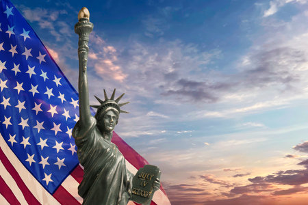 Statue of Liberty against American flag and sunset sky