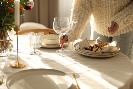 Woman setting table for dinner at home, closeupの写真素材