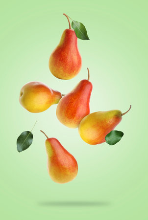 Fresh juicy pears in air on light green backgroundの写真素材