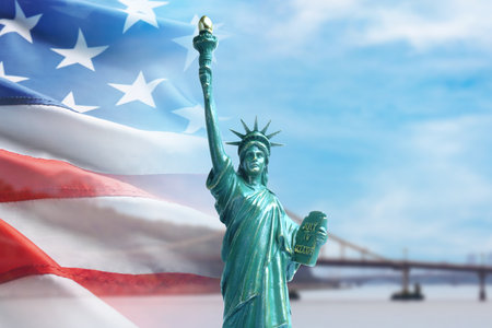 Statue of Liberty against American flag and bridgeの写真素材