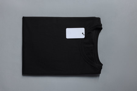 Blank black t-shirt on gray background, top view. Mockup for designの写真素材