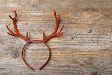 Beautiful reindeer headband on wooden background, top view with space for text. Christmas accessoryの写真素材